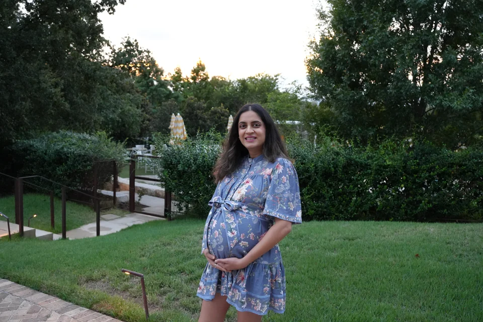 Mital in a floral blue dress in the garden